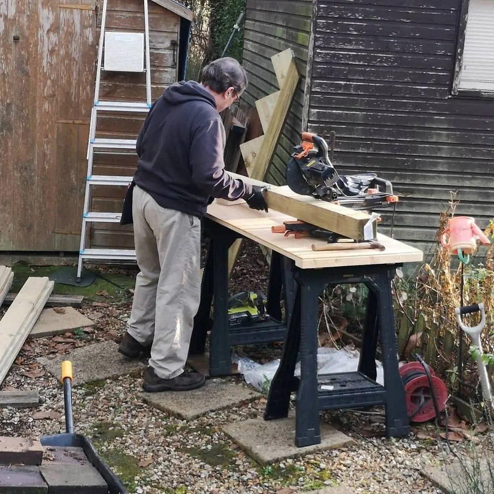Sean cutting timber on site
